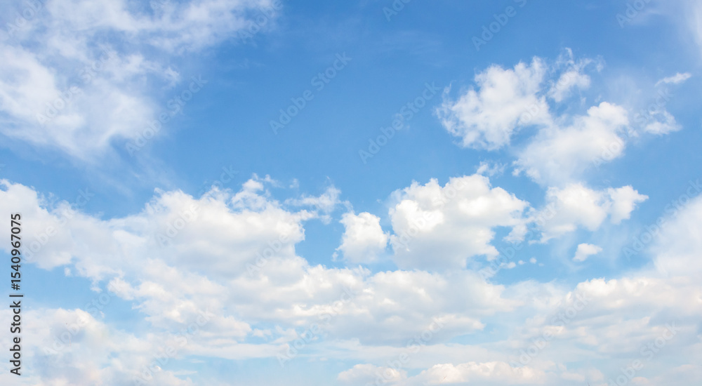 Obraz premium Expansive blue sky filled with fluffy white clouds, creating a serene atmosphere, ideal for backgrounds, designs, and nature-themed projects with ample copy space for text