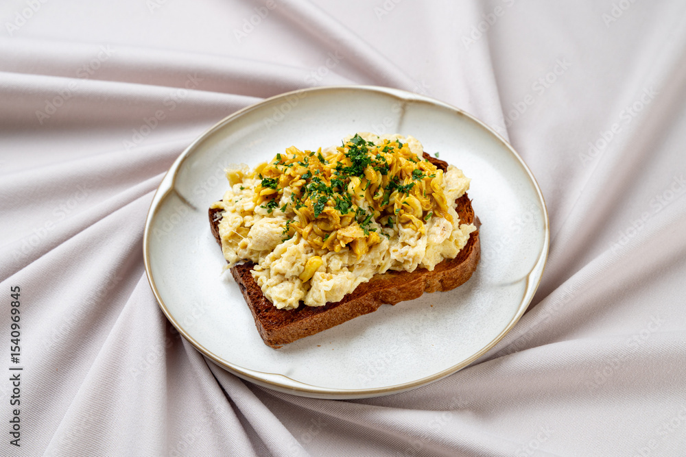 A delicious open-faced sandwich showcases creamy egg salad adorned with fresh herbs, resting on artisan bread. This culinary highlight is perfect for a relaxed brunch setting A delicious open-faced sandwich showcases creamy egg salad adorned with fresh herbs, resting on artisan bread. This culinary highlight is perfect for a relaxed brunch setting