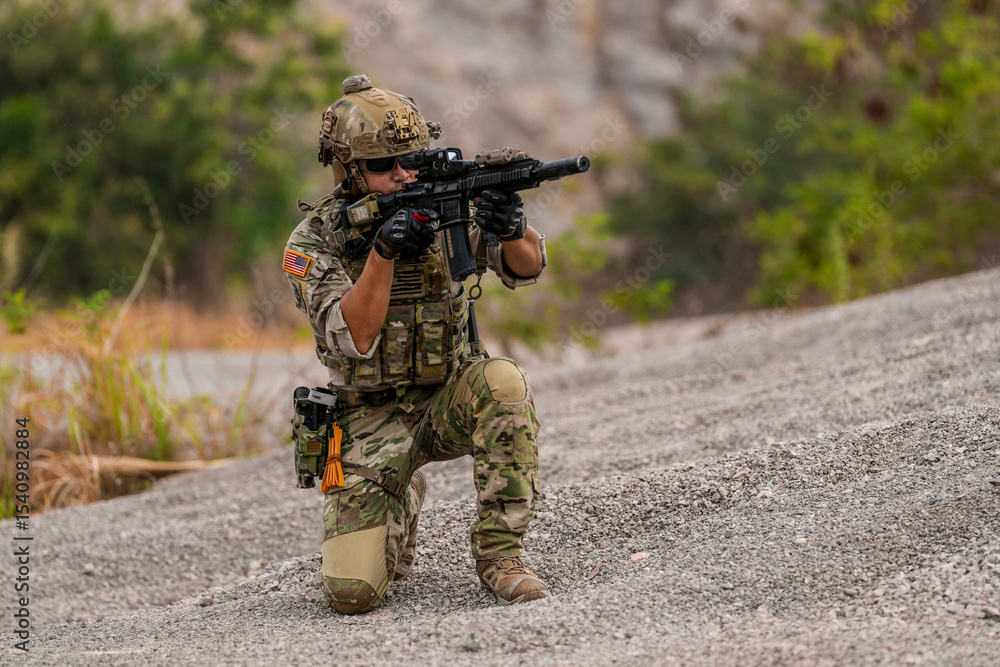 Fototapeta premium Special forces soldier uses a radio during a tactical operation while red flare smoke spreads across the rocky ground. Team communicates under high-alert battlefield conditions.