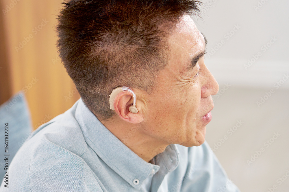 Obraz premium 補聴器を付けたシニア男性 リビング