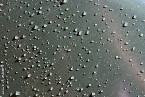 Water drops and scratches on a dark grey gray surface textured background