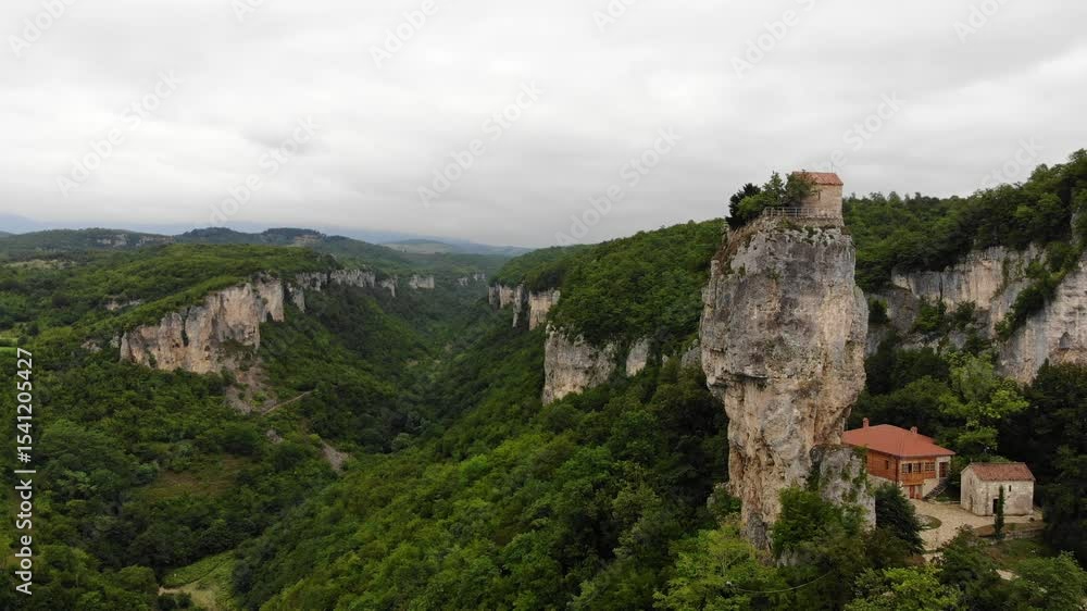 Drone aerial of Katskhi Pillar limestone monolith with Orthodox monastery on top in Chiatura, Georgia. Unique spiritual site of ascetic hermit monks, dramatic cliff in lush green landscape Drone aerial of Katskhi Pillar limestone monolith with Orthodox monastery on top in Chiatura, Georgia. Unique spiritual site of ascetic hermit monks, dramatic cliff in lush green landscape