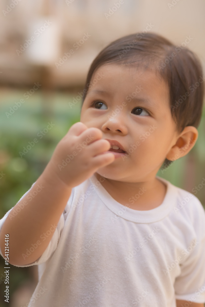 A baby is holding his finger to his mouth A baby is holding his finger to his mouth