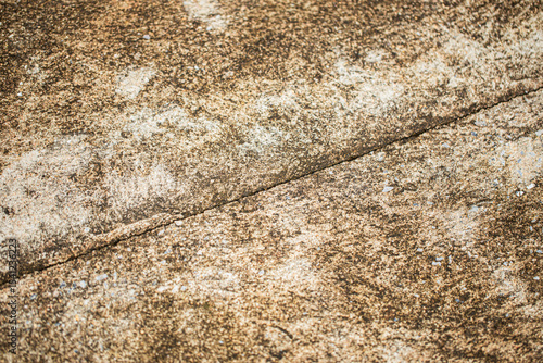 Close up shot of concrete floor with oblique linear cracking, in dirty light and dark brown color, retro style
