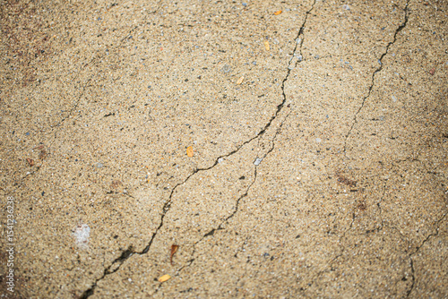 Close up shot of concrete floor with oblique cracking, in light brown color, retro style