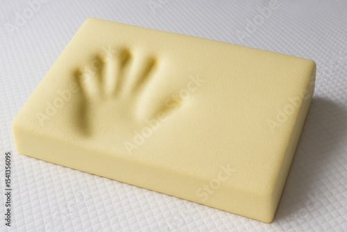 Memory Foam Pillow: An up-close shot of a soft, yellow memory foam pillow imprinted with the impression of a hand, hinting at comfort and personalized support.
