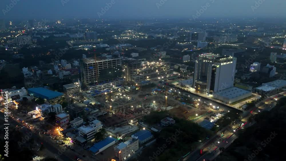Aerial view of Chennai, India, at night, showing brightly lit construction sites, modern buildings, and a distant tower. It captures a dynamic, developing city after dark. Aerial view of Chennai, India, at night, showing brightly lit construction sites, modern buildings, and a distant tower. It captures a dynamic, developing city after dark.