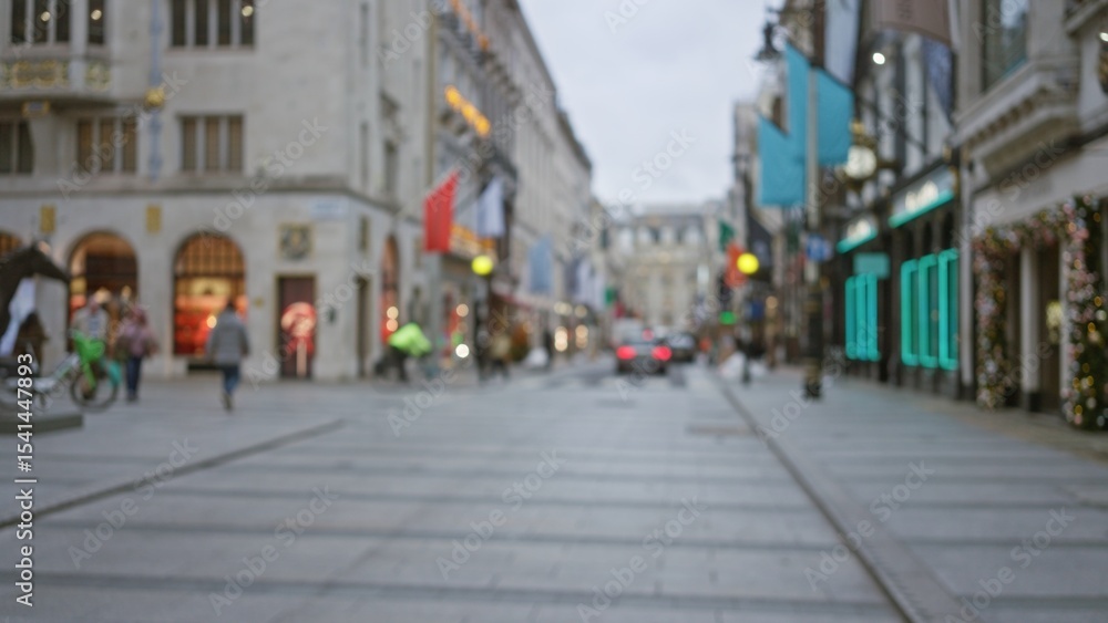 Fototapeta premium London street scene in winter with blurred pedestrians, festive decorations, and vibrant shopfront lights creating a cozy atmosphere under a cloudy sky.