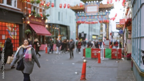 Photography Woman walking through blurred chinatown london street scene with winter attire and bokeh lights capturing urban life in united kingdom