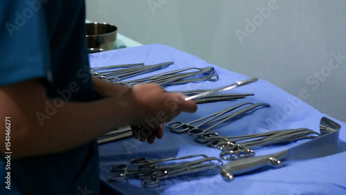 Schilderij op canvas Doctor hand arranging surgical instruments on sterile blue cloth in close up vie