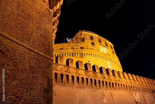 Night view of Castel Sant’Angelo in Rome, beautifully illuminated and surrounded by evening visitors