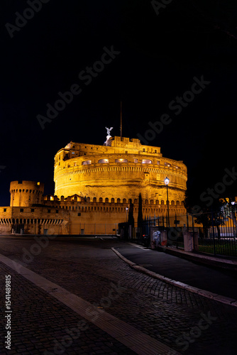 Night view of Castel Sant’Angelo in Rome, beautifully illuminated and surrounded by evening visitors