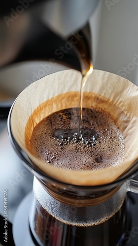 Hot water being poured over coffee grounds in a filter, brewing a fresh cup of coffee.