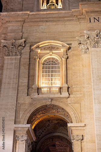 A nighttime view of the illuminated fountain in St. Peter’s Square, Vatican City, with cascading water and colonnades in the background