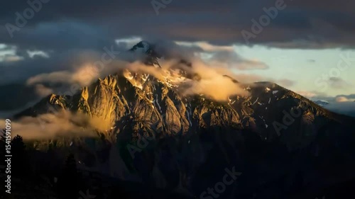 Mountain peaks shrouded in golden clouds at sunrise