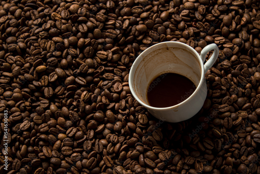A cup of coffee drunk on coffee beans. Freshly roasted coffee beans A cup of coffee drunk on coffee beans. Freshly roasted coffee beans