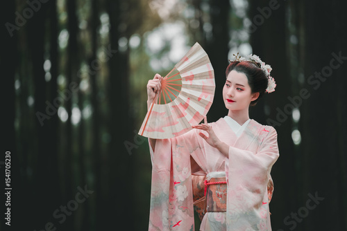 Elegant Woman in Kimono Holding Fan Amidst Serene Forest Background