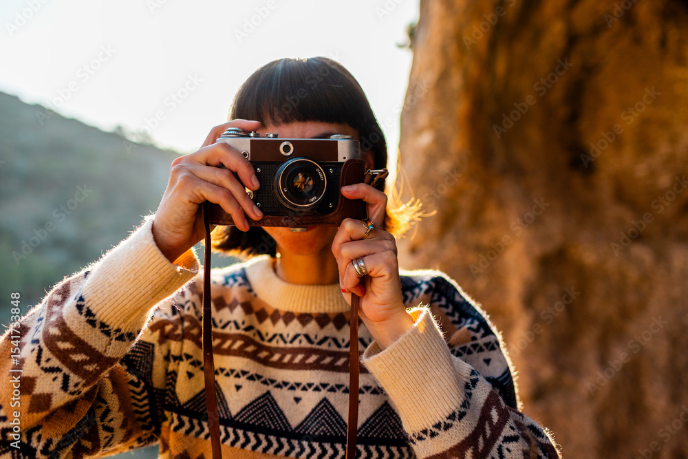Obraz premium happy woman in the mountains with a camera in her hands. girl relaxing and taking photos in the mountains. trekking and hiking. girl with a camera.