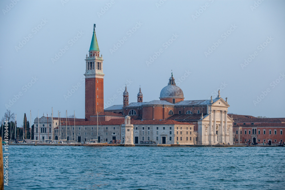 Fototapeta premium Panoramic view of San Giorgio Maggiore Basilica and its iconic bell tower rising majestically from the tranquil Venetian lagoon, showcasing the classical Renaissance architecture and historical grande