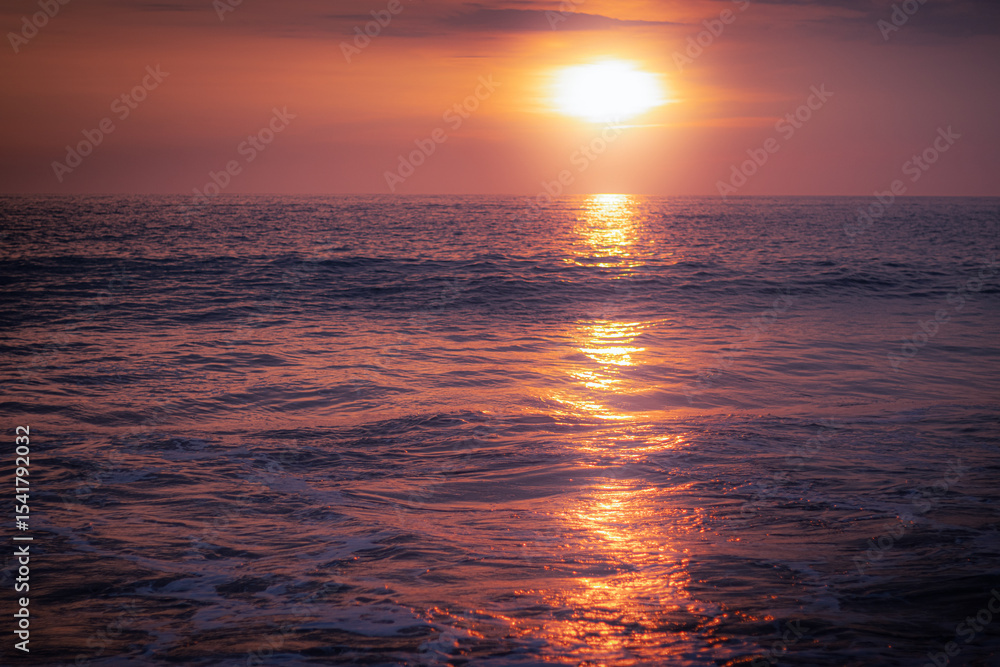 Obraz premium Sunset Over the Pacific Ocean – Warm Light Reflecting on the Water Surface