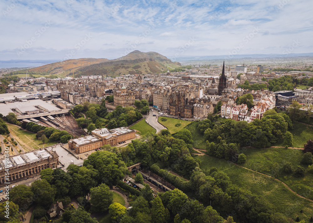 Fototapeta premium Ediburgh Scotland: 18th May 2025: Edinburgh Skyline and Edinburgh Waverley station area showcasing the historic skyline and surrounding hills and a cloudy overcast day