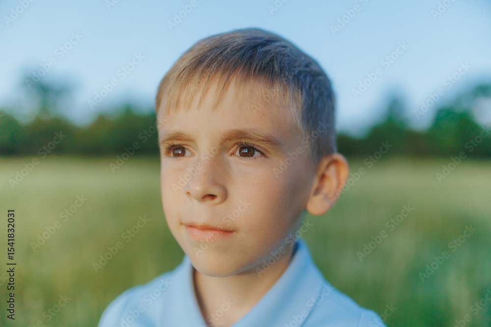 Soft Close-Up of Reflective Young Boy in Peaceful Field Setting Soft Close-Up of Reflective Young Boy in Peaceful Field Setting