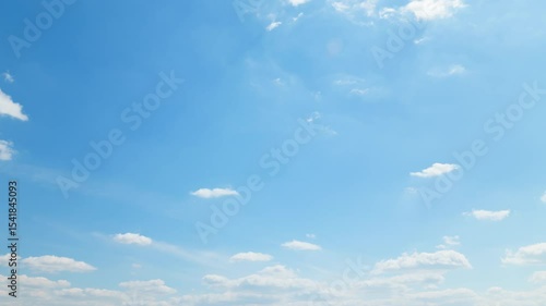 A beautiful blue sky with soft, white clouds, captured in a timelapse for an abstract background