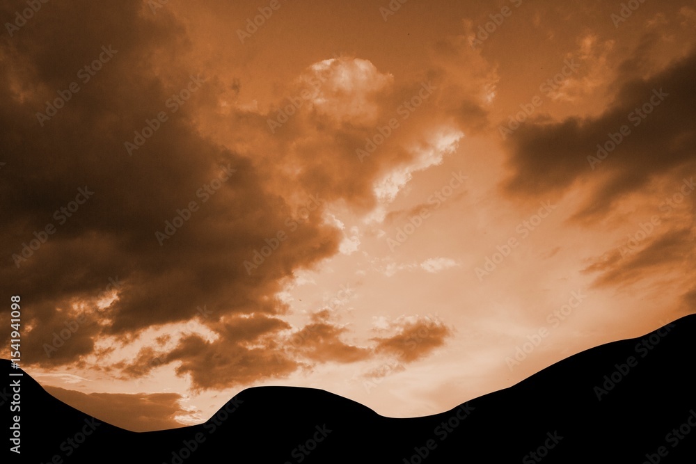 Obraz premium Silhouette of rolling dunes is spanning width in minimalist flat design, with warm glowing clouds