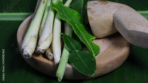 Принти на полотні Fresh Culinary Herbs: A close-up shot of fresh lemongrass stalks and kaffir lime leaves, arranged artfully on a wooden mortar, ready to be incorporated into culinary creations