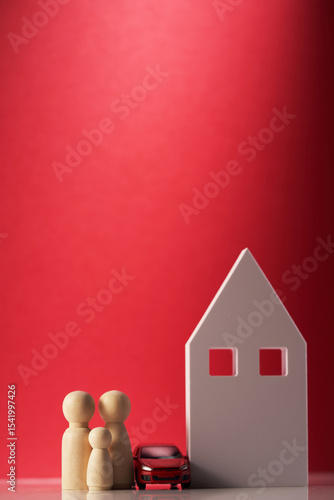 Wooden house with car and wooden peg dolls on red background
