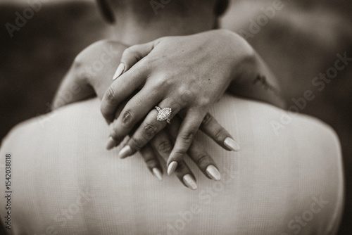 black and white couple holding hands with diamond ring