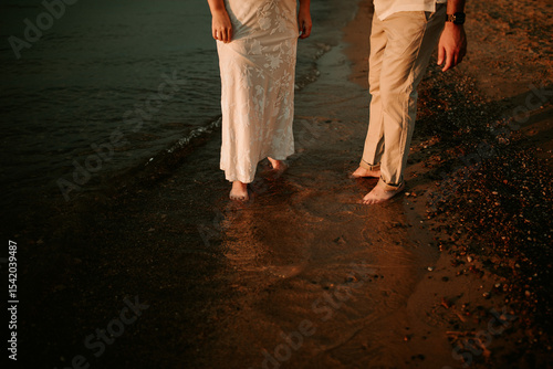 couple barefoot in the water on the beach