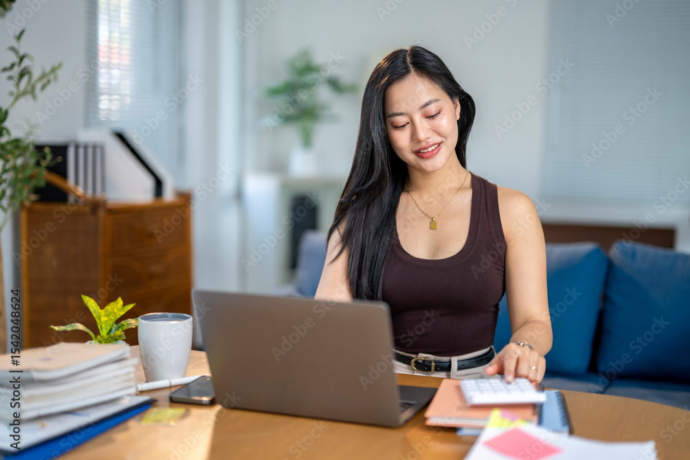 A woman is sitting at a desk with a laptop and a stack of books A woman is sitting at a desk with a laptop and a stack of books