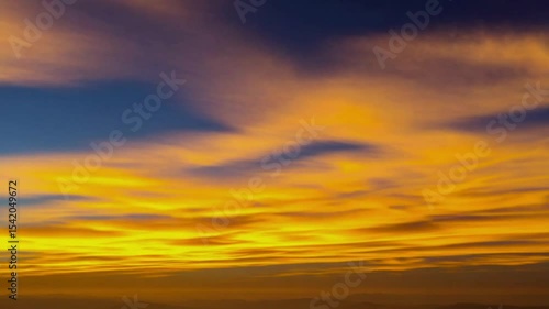 Vibrant sunset hues paint the evening sky with streaks of gold and orange, creating a dramatic and colorful celestial display.