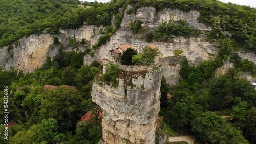 Drone aerial of Katskhi Pillar limestone monolith with Orthodox monastery on top in Chiatura, Georgia. Unique spiritual site of ascetic hermit monks, dramatic cliff in lush green landscape