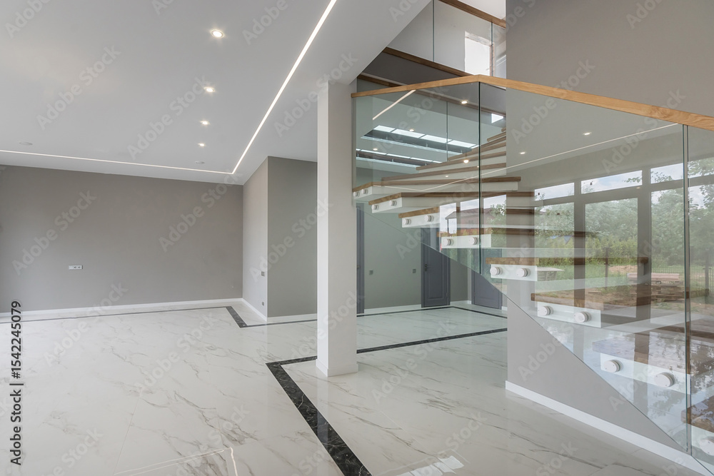 Obraz premium Modern design of the lobby of a luxury mansion. Stairs with wooden steps and glass railings. Unfurnished.