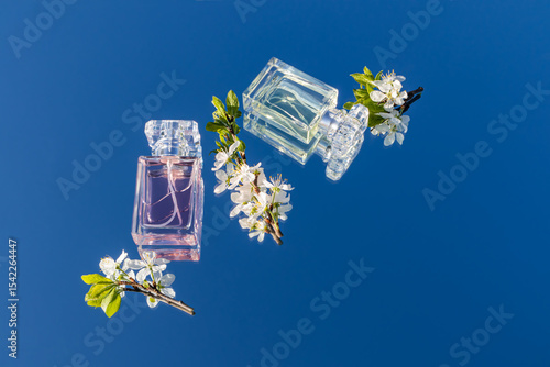 Perfume bottles with flowers and blue sky background