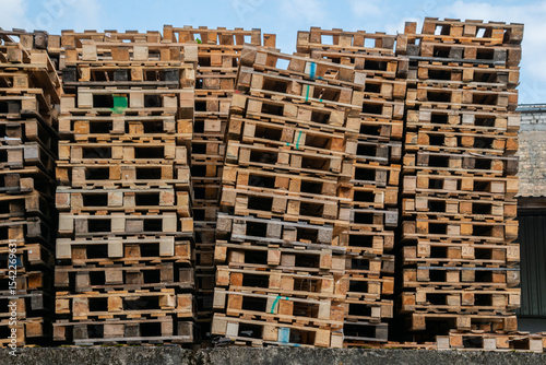 Tilted stack of used wooden pallets in storage area