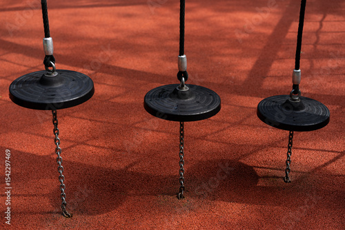 disc swings hanging above red rubber safety surface