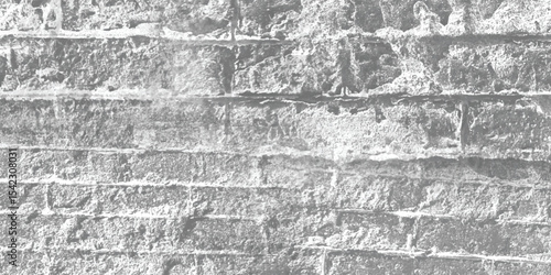 Monochrome photograph of a stone wall, emphasizing its form, shadows, and the interplay of light on its rugged surface.
