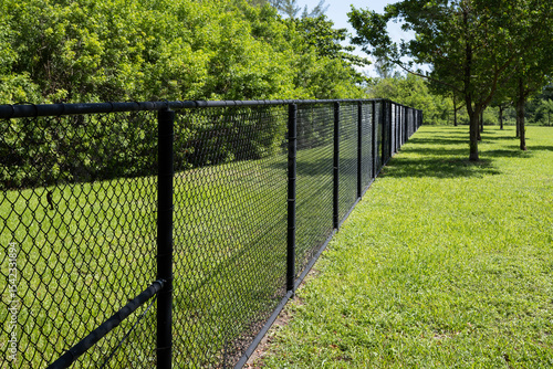 black chain link fence in park surrounded by green grass 