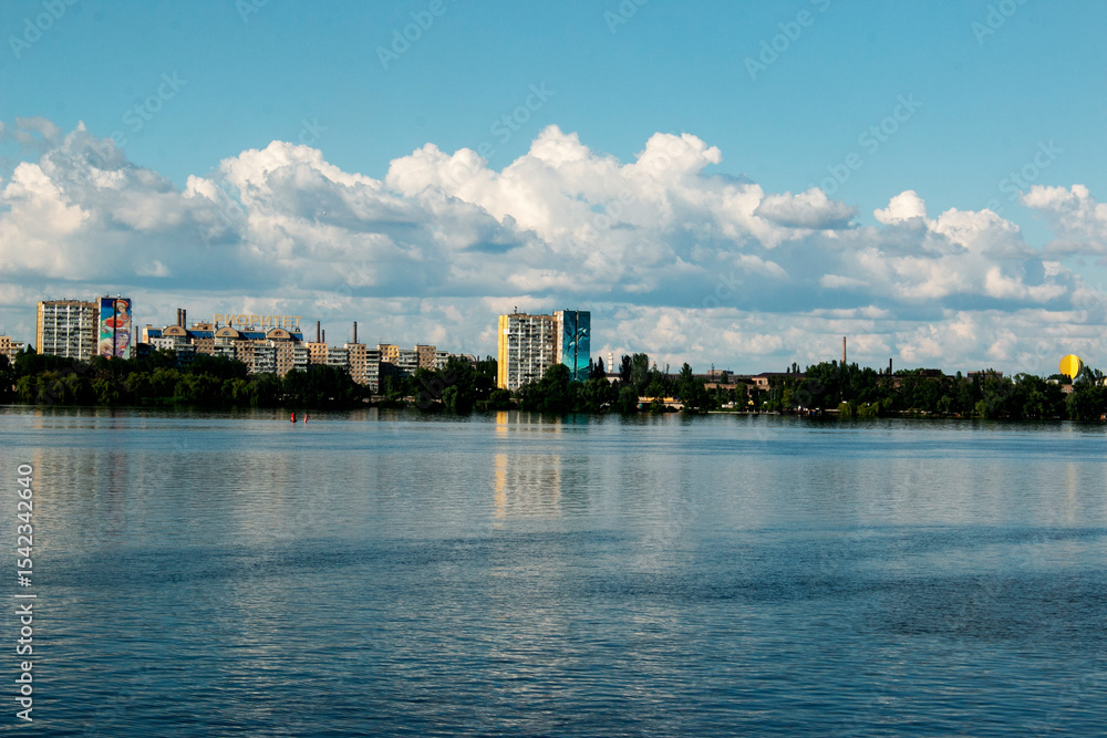 Naklejka premium Panoramic view of the left bank of the Dnieper River. Ukraine. The city of Dnieper. Reflection of sky with clouds on the water surface.