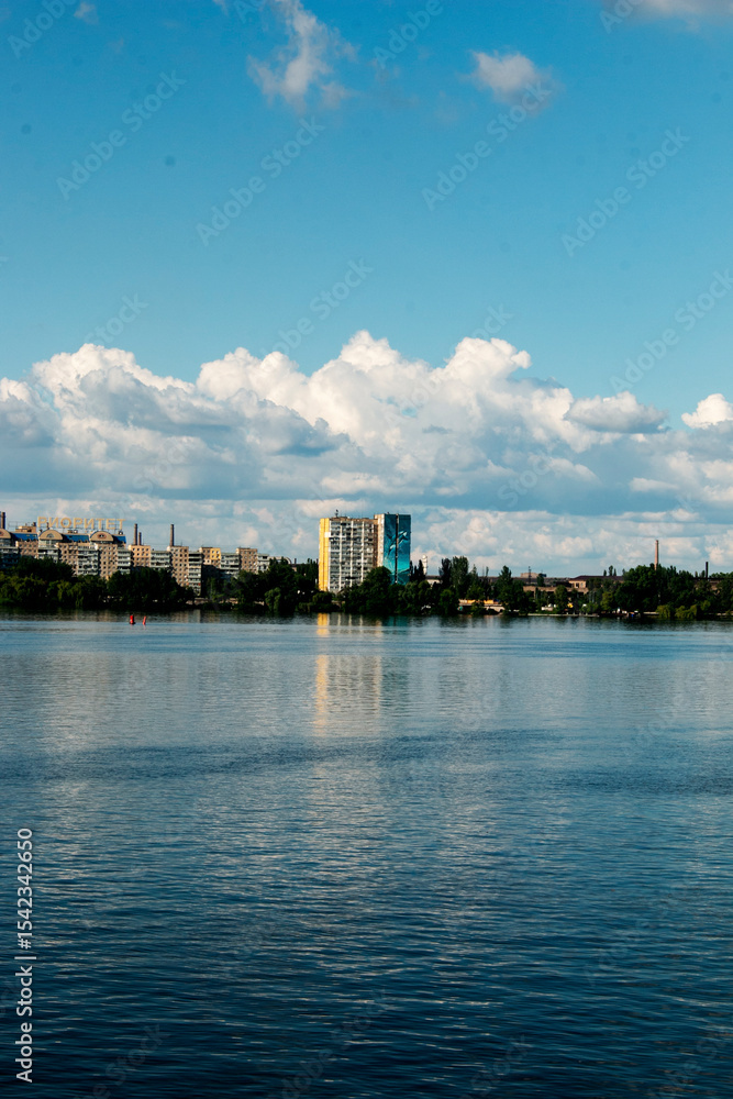 Naklejka premium Panoramic view of the left bank of the Dnieper River. Ukraine. The city of Dnieper. Reflection of the sky with clouds on water surface.