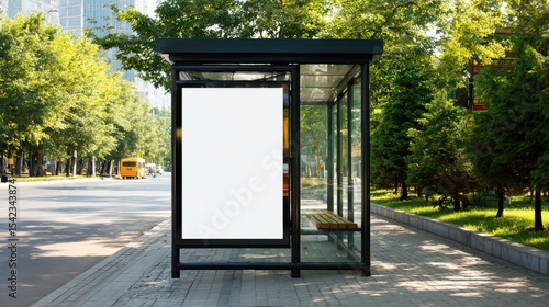 Stunning photo of modern bus stop shelter with blank advertising billboard in urban setting. Black metal frame, glass panels, green trees. Sunny day. Public transportation.