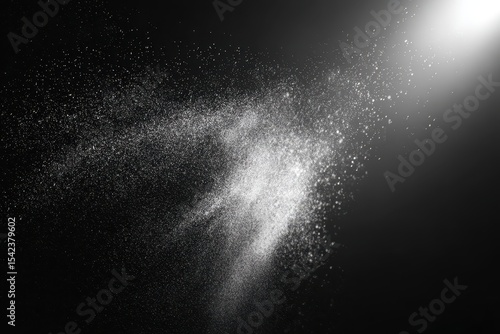 Floating dust particles illuminate a black matte background, creating a captivating and ethereal atmosphere in a creative and artistic display of light and texture