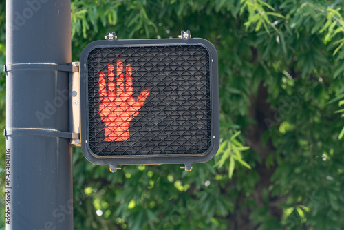 Illuminated led orange hand stop do not walk crosswalk sign with copy space