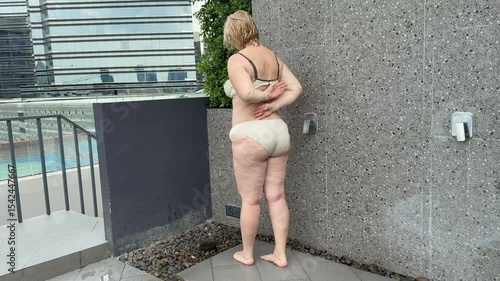 plump adult woman in the shower outside