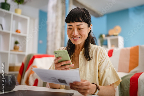 Tableau sur toile Japanese mature woman use mobile phone to pay bills,