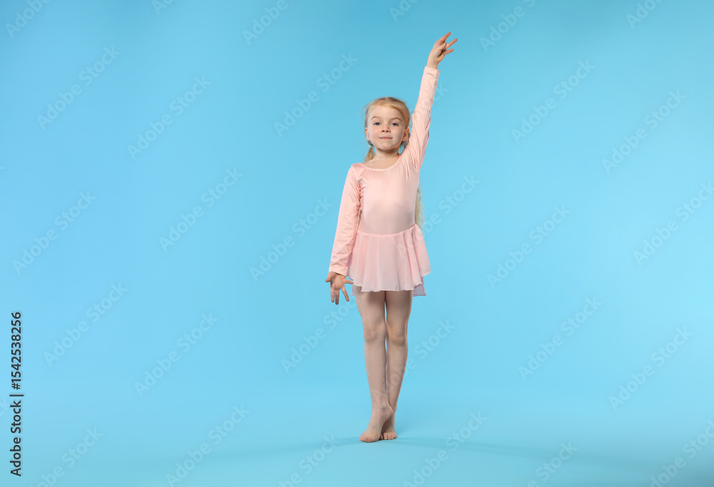 Cute little girl dancing on light blue background Cute little girl dancing on light blue background