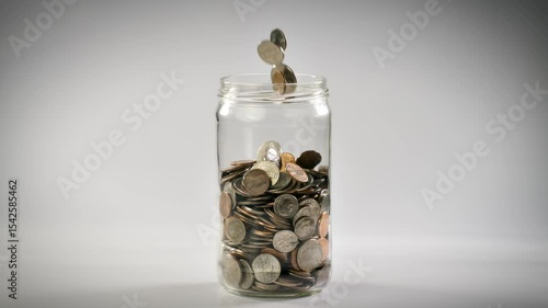 Wallpaper Mural Close-up shot of coins falling into a coin jar in slow motion. Torontodigital.ca